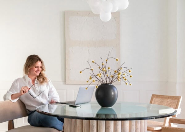 A woman sitting at a table with a laptop