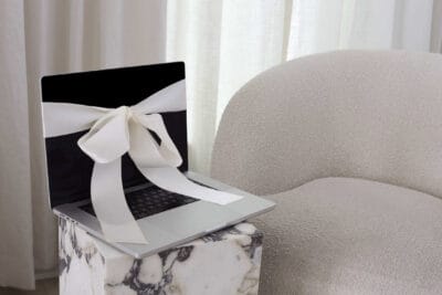 A laptop with a bow on it sitting on a chair