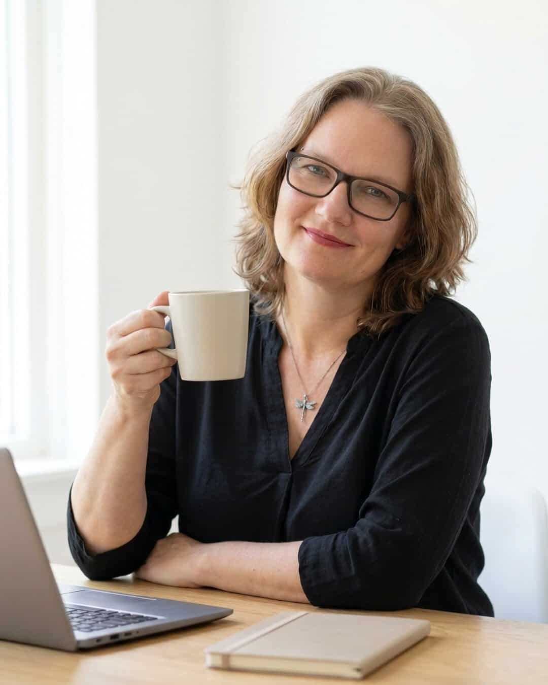 Diana aan haar bureau met een koffiemok en laptop