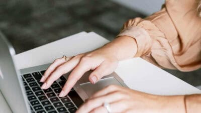 Handen op een laptop bij een artikel over WordPress-updates, back-ups en websiteonderhoud