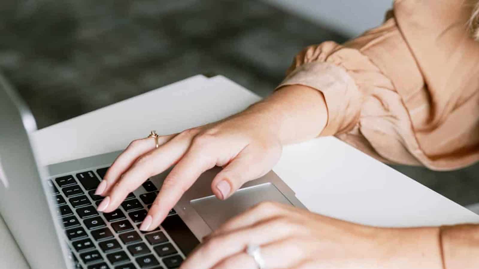 Handen op een laptop bij een artikel over WordPress-updates, back-ups en websiteonderhoud